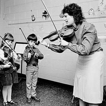 Children are taught to play the violin at 赌钱app可以微信提现.