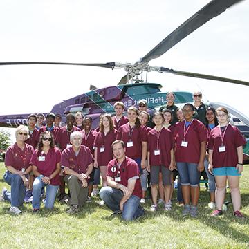 Healthcare students pose by a LifeFlight helicopter.