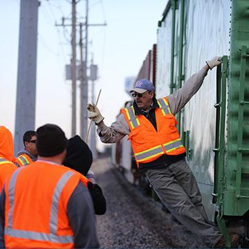 NARS students listen to an instructor in a rail yard.