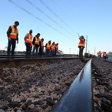 An instructor addresses students in a rail yard.