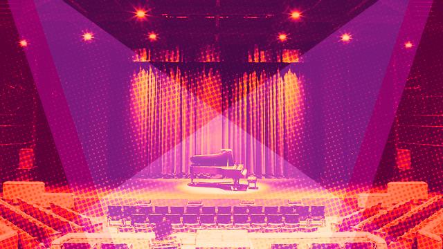 An empty piano on stage in an empty theater.